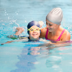 Portrait of mother and boy swimming in pool
