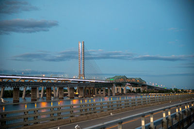 Bridge over city against cloudy sky