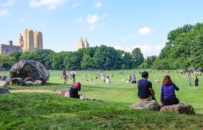 People relaxing on grassy field