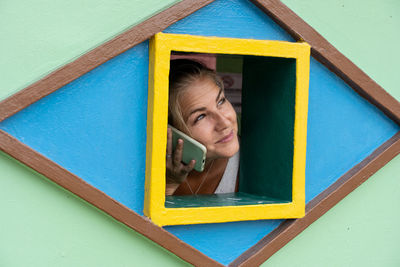 Portrait of woman against blue window