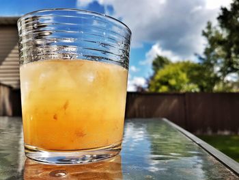 Close-up of orange cocktail on table in back yard