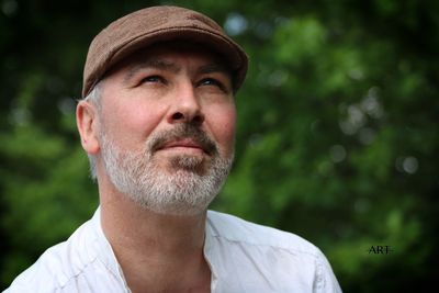 Close-up of handsome mature bearded man wearing flat cap