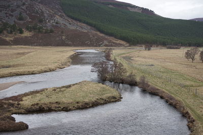 Scenic view of river by stream against sky