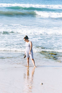 Woman standing on shore at beach