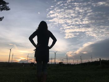 Low angle view of silhouette woman standing on field against sky