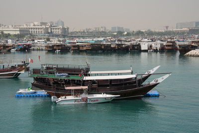 Boats in river with city in background