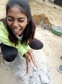 High angle view of smiling young woman lying on rock