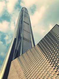 Low angle view of modern building against cloudy sky