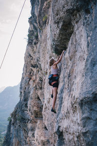 Full length of woman climbing on rock formation