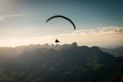 Person paragliding against sky