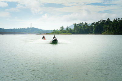 People on boat against sky