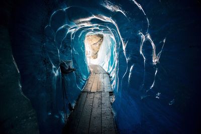 Empty boardwalk amidst ice cave tunnel