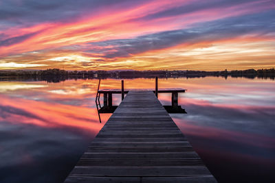 Pier over lake against sky during sunset