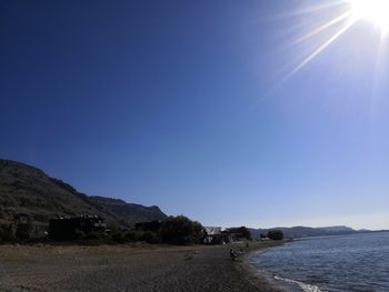 Scenic view of sea against clear blue sky on sunny day