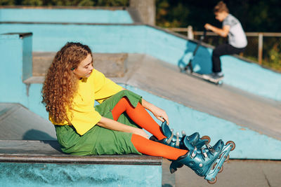 Full length of woman sitting on skateboard