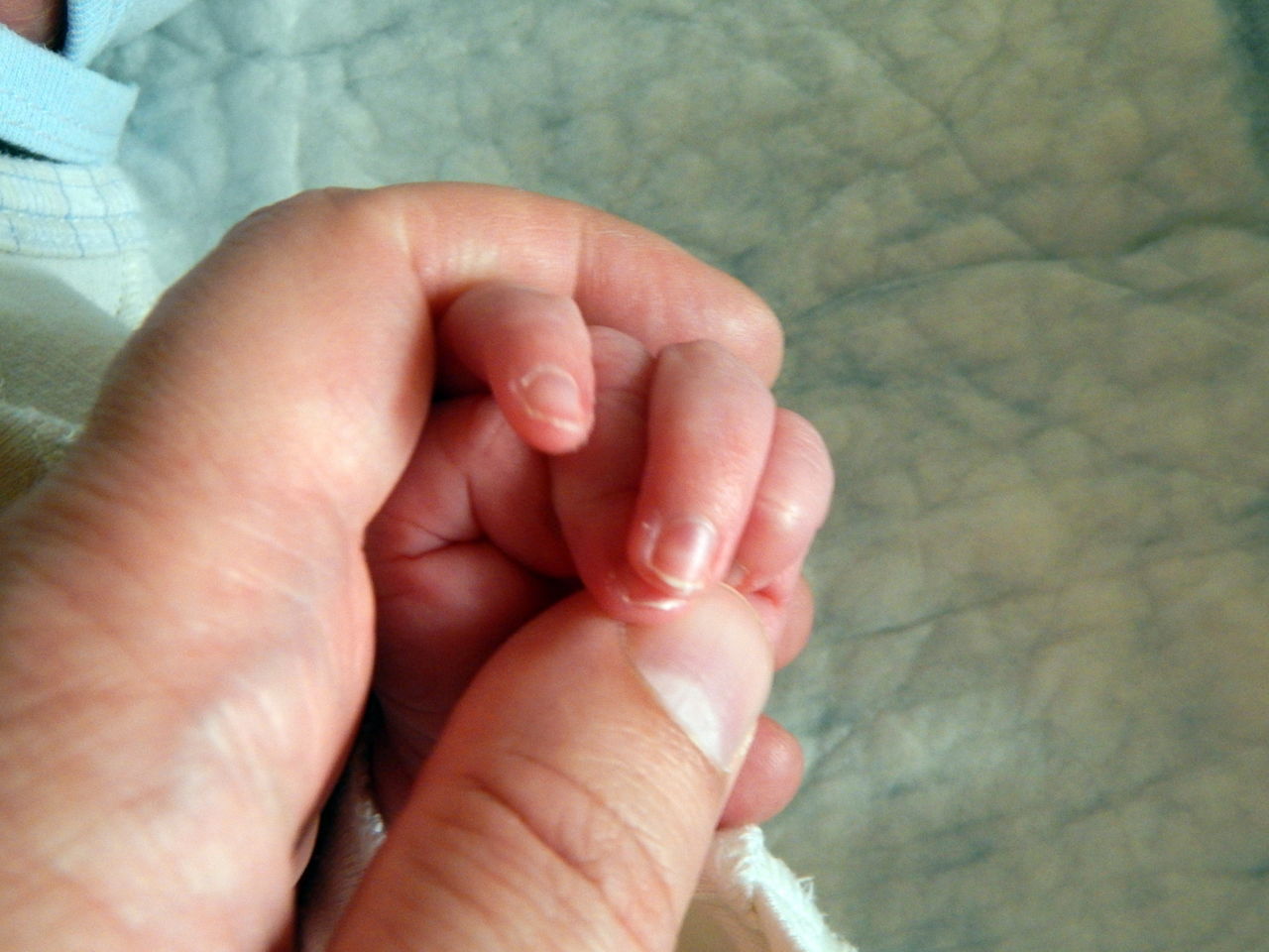 CLOSE-UP OF HANDS HOLDING BABY