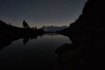 Scenic view of lake against sky at night