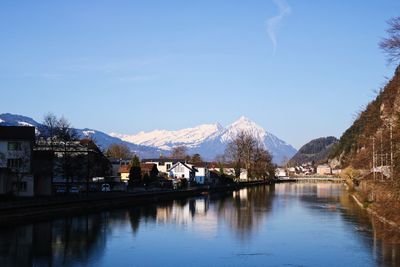 Scenic view of lake by buildings against sky