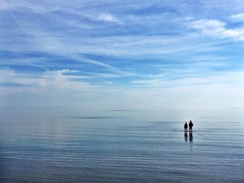 People swimming in sea against sky