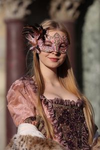 Portrait of smiling beautiful teenage girl wearing venetian mask