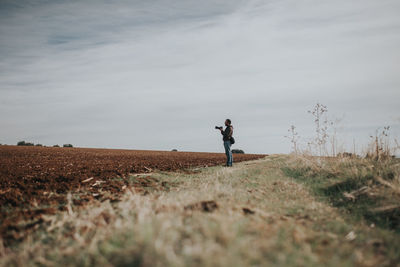 Man standing on field against sky