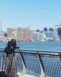 Man photographing cityscape against clear sky