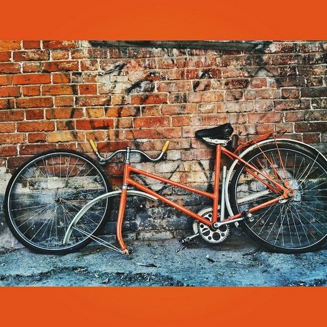 bicycle, transportation, wall - building feature, architecture, built structure, mode of transport, building exterior, land vehicle, stationary, brick wall, parked, parking, graffiti, wall, sidewalk, street, outdoors, day, no people, wheel