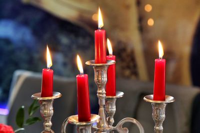 Close-up of illuminated red candles on table