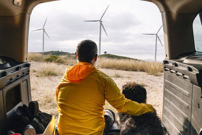 Spend the day with the dog in nature. windmills background