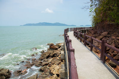 Natural scenic shot of rocky cliff on the sea and ocean wave which the walking path bridge