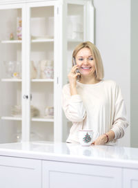 Beautiful smiling woman talking on phone at home