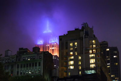 Illuminated buildings against sky at night
