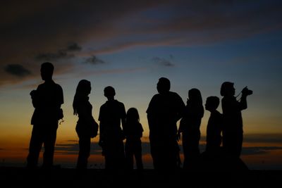 Silhouette people against sky at sunset