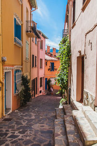 Narrow alley amidst houses and buildings in city