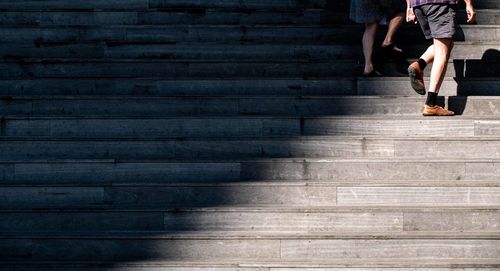 Low section of woman walking on staircase