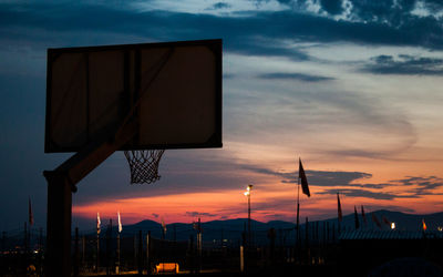 Low angle view of basketball hoop against sky during sunset