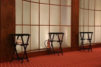 Empty chairs and table against wall in building