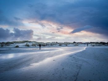 Scenic view of frozen landscape against sky during winter