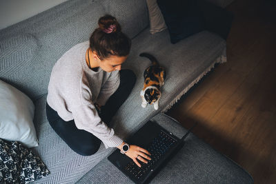 High angle view of woman relaxing on sofa at home