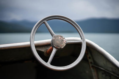 Close-up of metal railing against sea