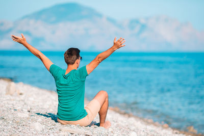 Full length of man with arms raised on beach