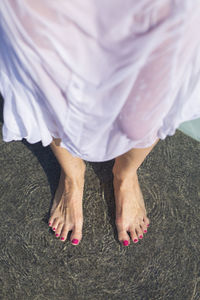 Low section of wet woman standing on floor