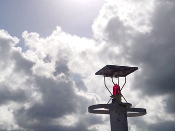 Low angle view of silhouette crane against sky