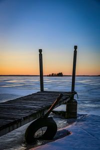 Lifeguard hut on beach against clear sky during sunset
