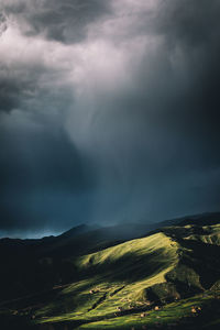 Scenic view of landscape against storm clouds