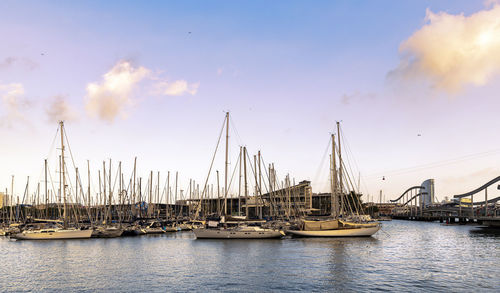 Sailboats moored in sea against sky