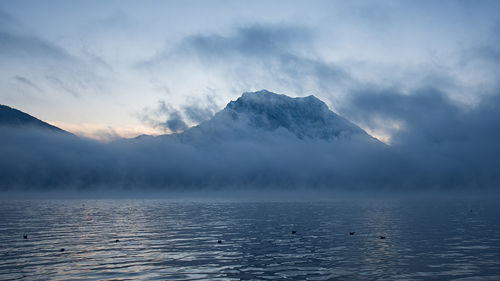 Scenic view of lake by mountains against sky