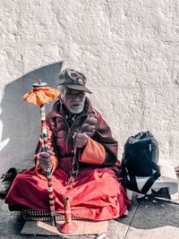 Portrait of man sitting against wall