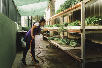 Female entrepreneur watering plants at garden center