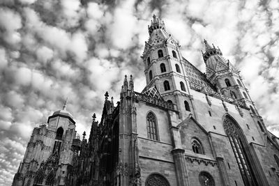 Low angle view of bell tower against cloudy sky